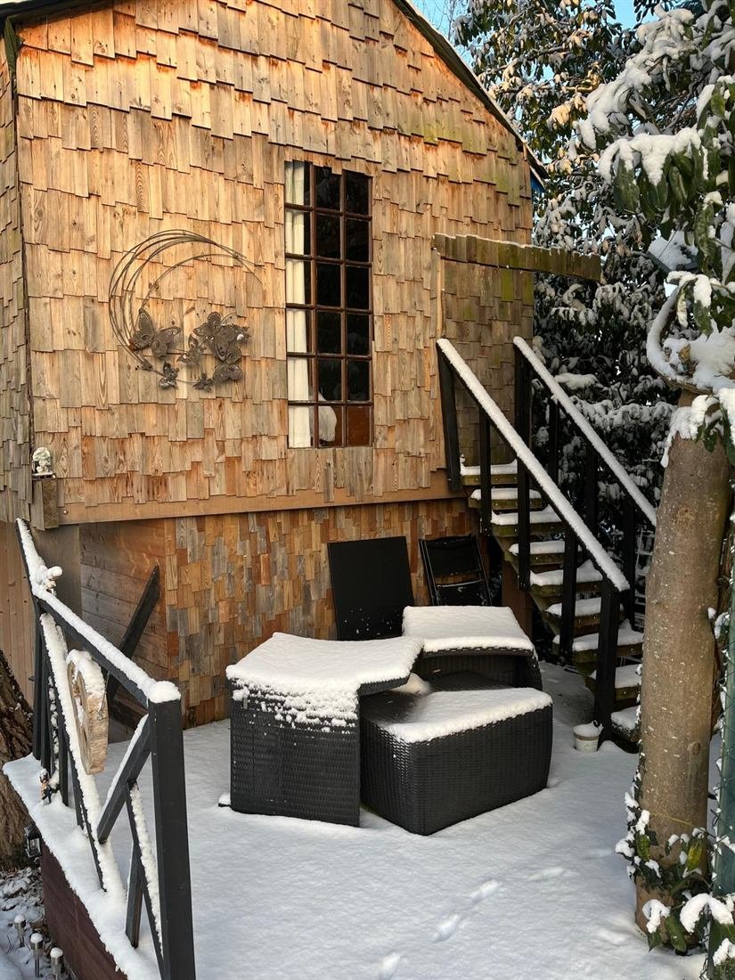 La Romantique sous la neige, escalier en bois menant à la cabane perchée
